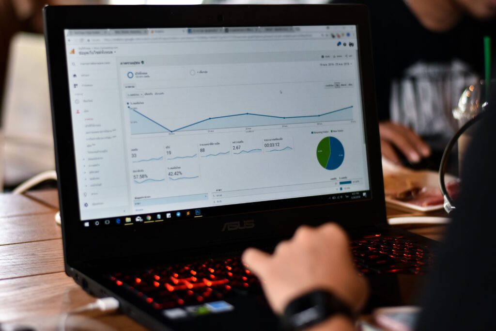 This is an image of a laptop with a google analytics dashboard up with a person's hand on the keyboard.