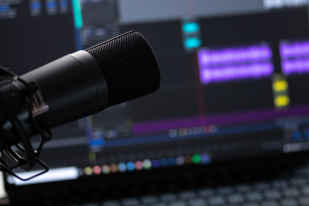 This is an image of a microphone with an editing program on the computer in the background.