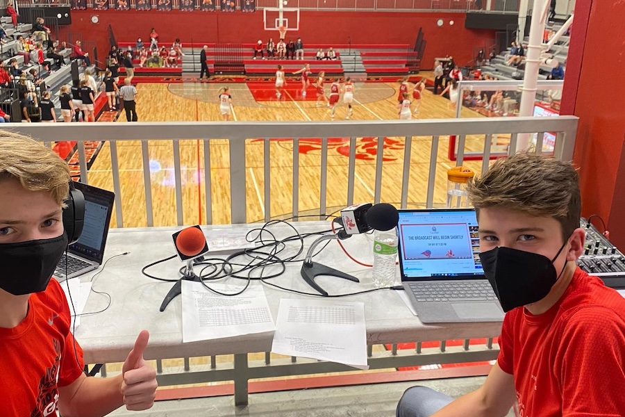 Photo of two boys commentating a high school basketball game