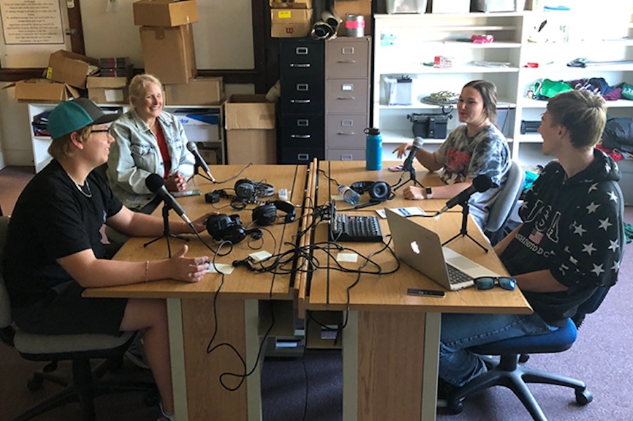 Photo of 4 people recording a podcast