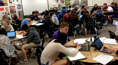 Photo of students at tables working on computers
