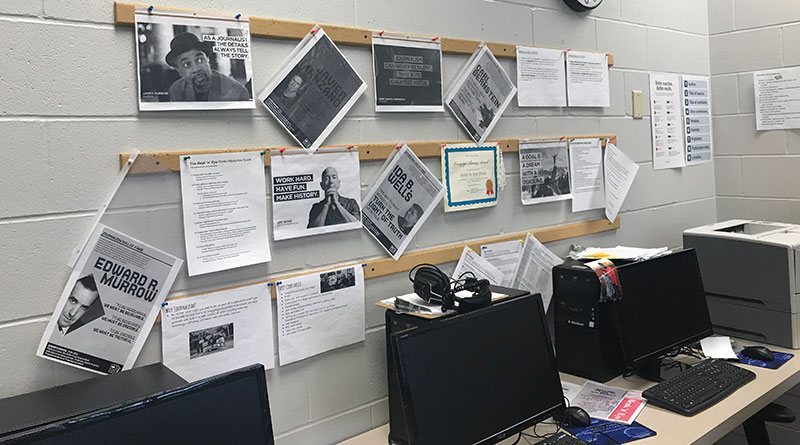 Photo of a newsroom with computers and print-outs of famous news stories