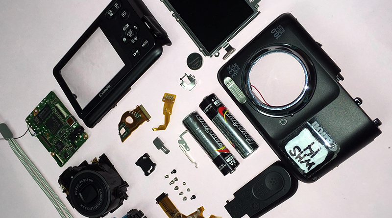 Photos of outdated camera equipment like a camera, batteries, etc