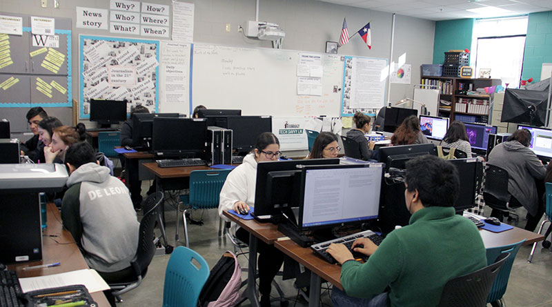 Photo of a newsroom with students working at desks and computers in Texas