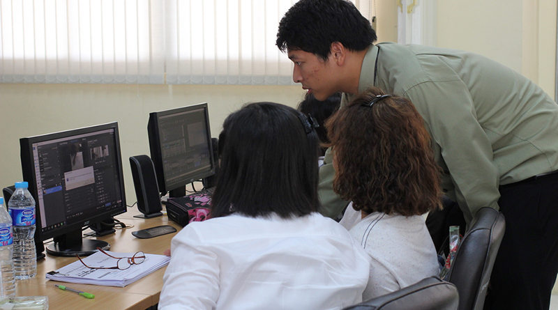 Photo of an adviser working with students on a computer