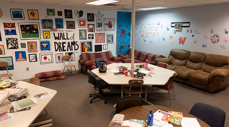 Photo of a newsroom decorated with painting and couches