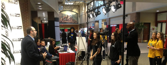 Photo of students running a camera to record an interview at a convention