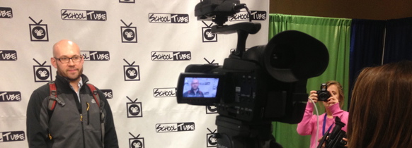 Photo of a student recording a man
