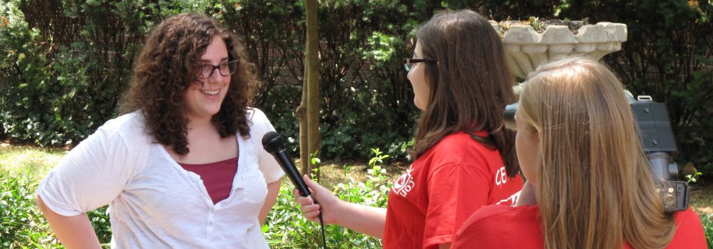 Photo of 2 girls recording an interview with another girl