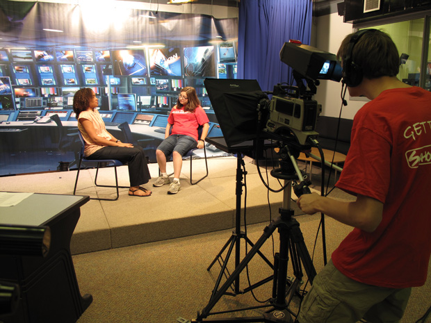 Photo of a man recording an interview between two girls