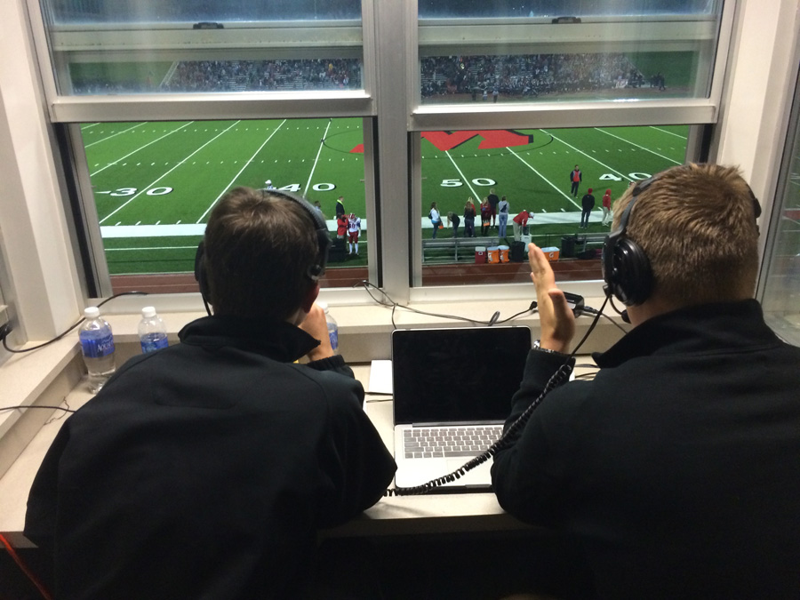 Photo of 2 boys commentating a high school football game