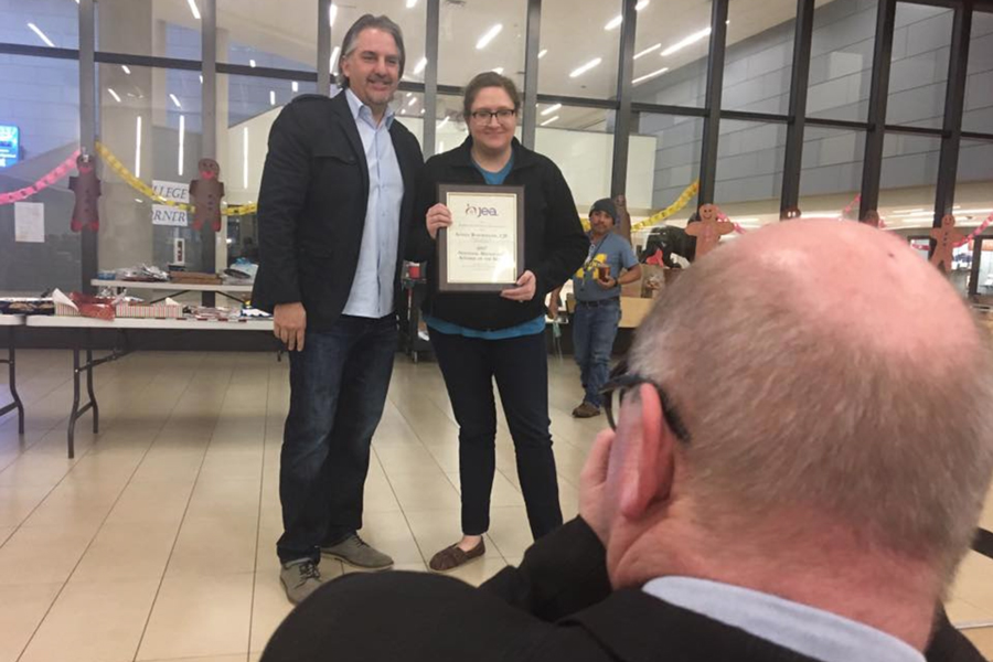Photo of Alyssa posing with an adviser after winning JEA Broadcast adviser of the year