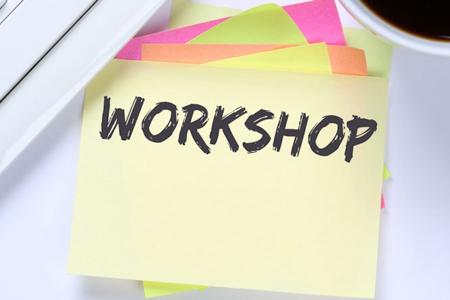 Post-it notes stacked on top of each other and the top note reads workshop