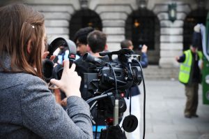 Photo of a person recording an event and putting on headphones