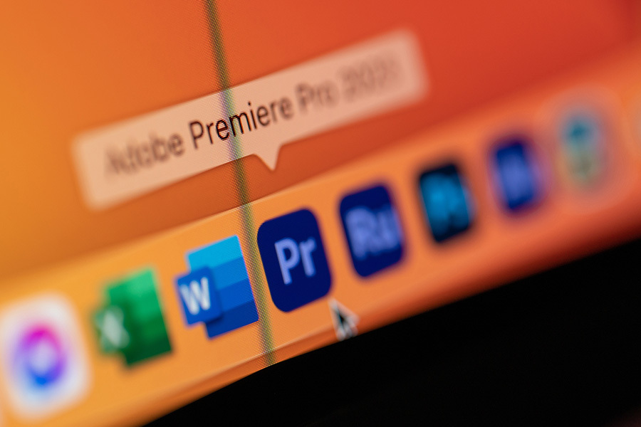 Photo of mouse hovering over the Adobe Premiere Pro program on a computer