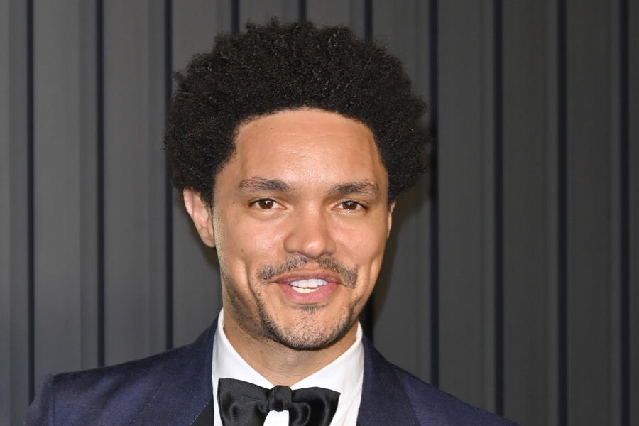 This is a head shot of Trevor Noah. He's smiling for the camera and has a black bow tie on. Editorial credit: Featureflash Photo Agency / Shutterstock.com