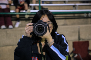 Image of teenage girl pointing a camera as if about to take a photo.