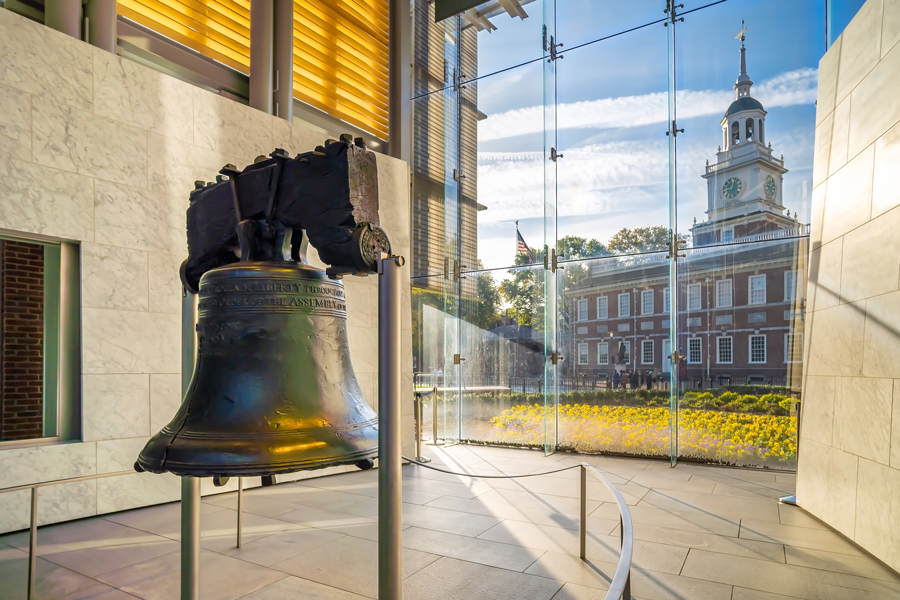 This is a photo of the Liberty Bell on the left in the foreground with Independence Hall on the right in the background.