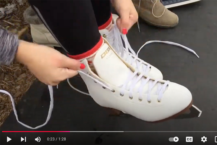 This is a photo if a person who is lacing white ice skates.