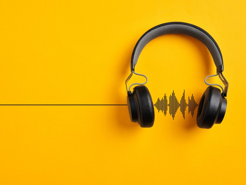 This is a pair of over the ear headphones set on a yellow background.