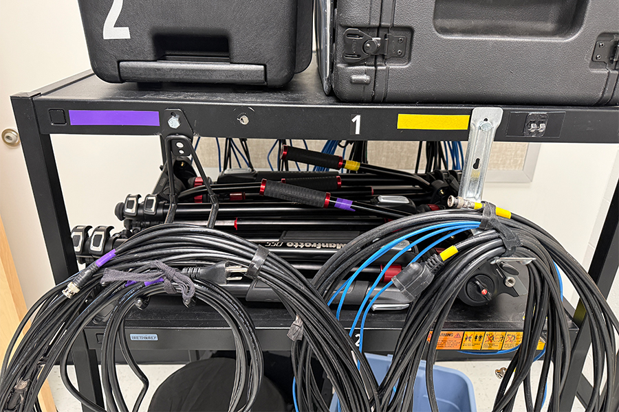 This image shows a cart that has cables wrapped and hanging from it. The cables are color coded with tape on them differentiating two sets.