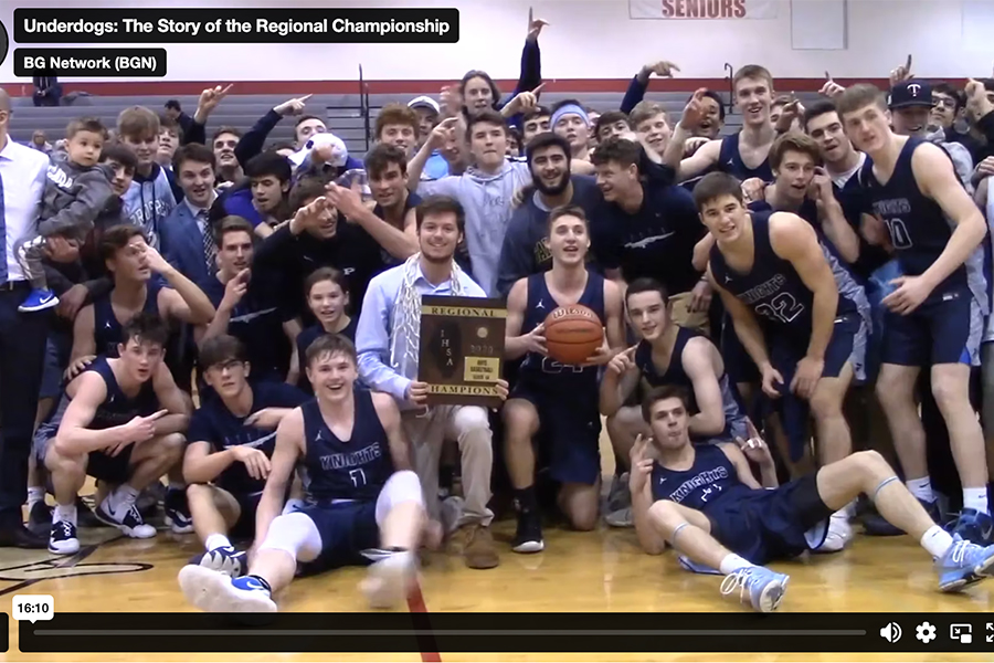This is an image of a high school basketball team posing for a photo after winning a tournament.